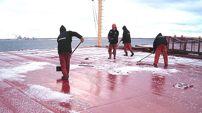 Seafarers clearing ice off a deck