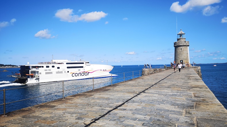 Guernsey, UK: August 25, 2018: A car ferry passes the lighthouse in St Peter Port. Condor Ferries is an operator of passenger and freight ferry services between the UK, Guernsey, Jersey and France.  J By jax10289