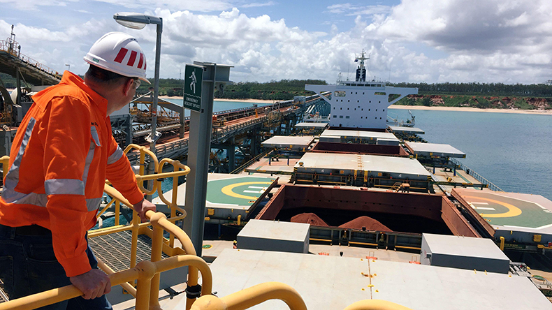 Rio Tinto worker looks at a ship that is loaded with bauxite in Australia