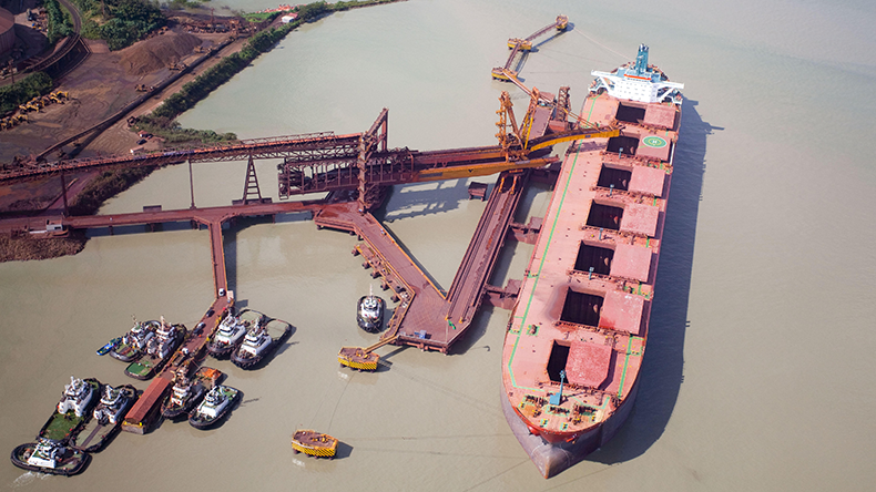 Aerial view of bulker vessel being loaded with iron ore