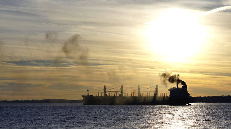 Tanker at sunset, with smoke from funnel