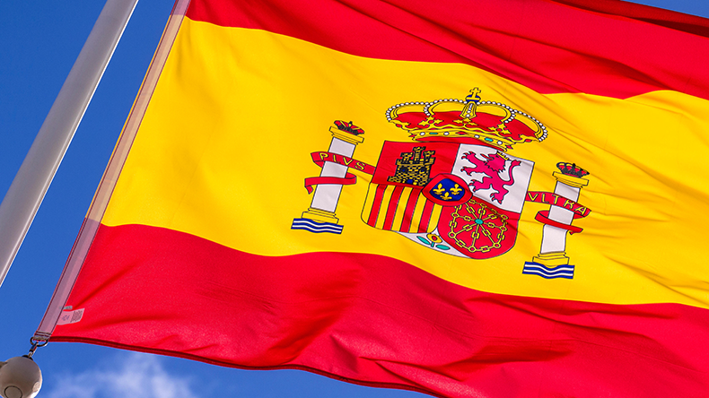 SPANISH FLAG fluttering in the breeze with blue sky behind