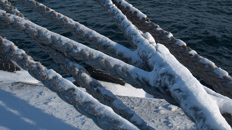 Mooring ropes covered in snow at a Danish port