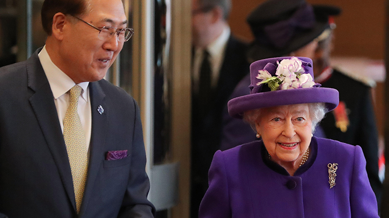 Queen Elizabeth II walks with secretary-general of the International Maritime Organization Kitack Lim
