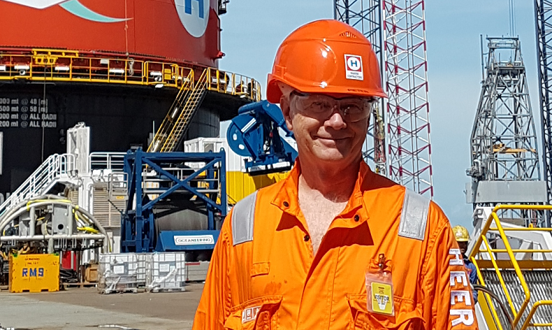 Heerema Marine Contractors' founder, Pieter Heerema posing in front of world's largest semisub crane vessel, Sleipnir