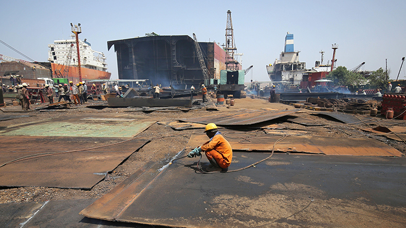 Workers dismantle a decommissioned ship at Alang shipyard 2018