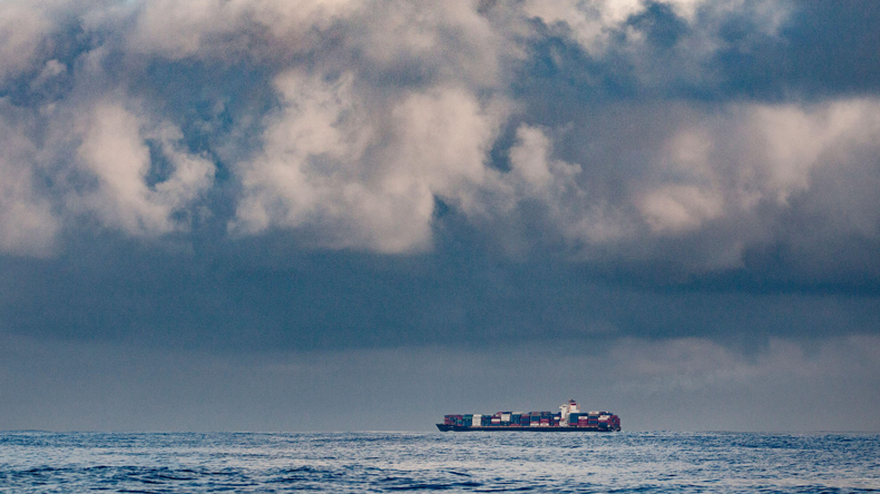 Containership sailing under stormy clouds