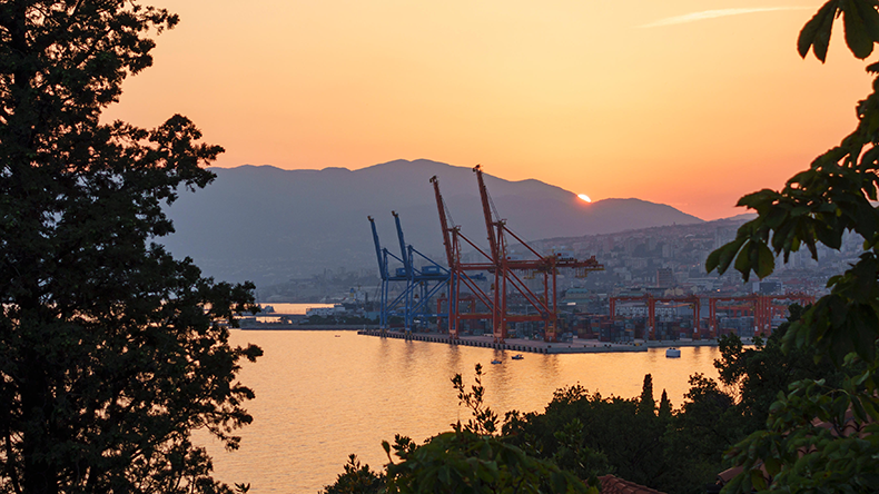 Rijeka, Croatia. Sunset over the port and the dockyard cranes with the mountains of Istria in the background.  Image ID: EYY8AY Credit: Alex Ramsay / Alamy Stock Photo 