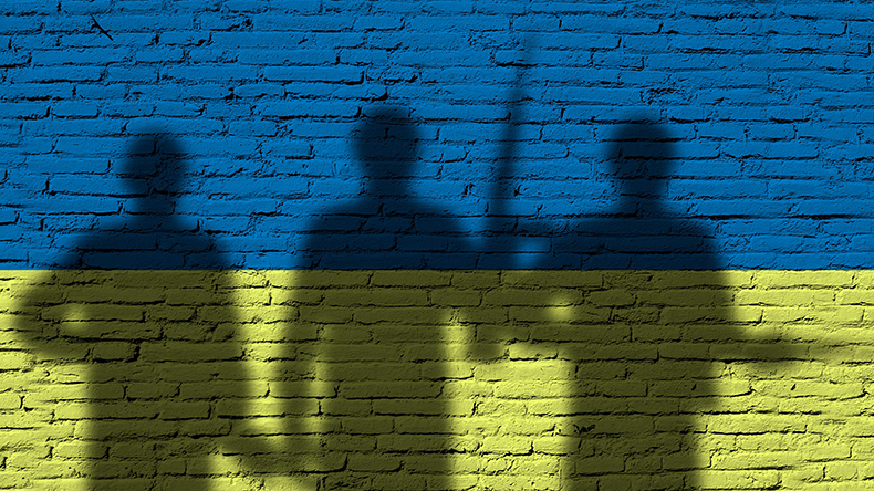  Flag of Ukraine painted on a brick wall with soldiers. War between Ukraine and Russia - Image ID: 2HWB9GX  Credit: cunaplus / Alamy Stock Photo 